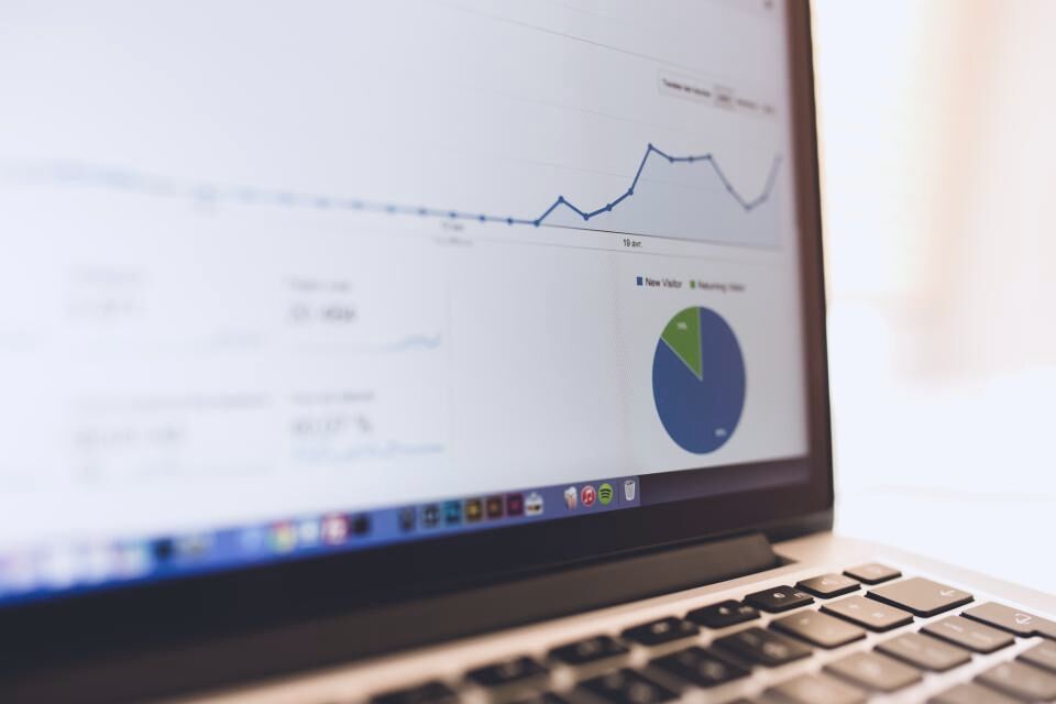 Gráficas de crecimiento y analítica de redes sociales en una laptop